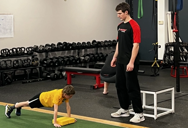 kid do push ups with coach